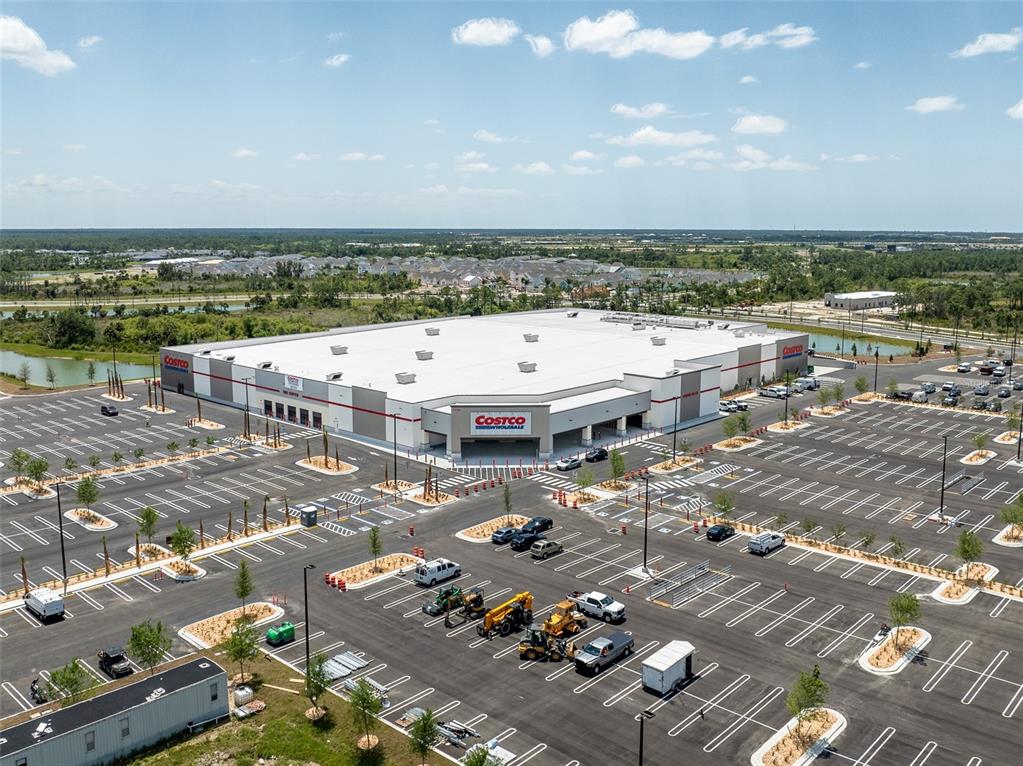 An aerial view shows a large Costco warehouse store surrounded by a vast parking lot — Lot 26, GLOBE TERRACE, NORTH PORT, FL