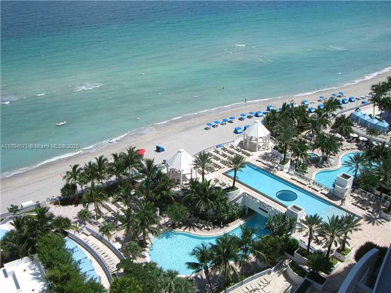 An aerial view of a beachfront resort with multiple swimming pools and palm trees — 3535 S OCEAN DR # 2102, Hollywood FL 33019, HOLLYWOOD, FL