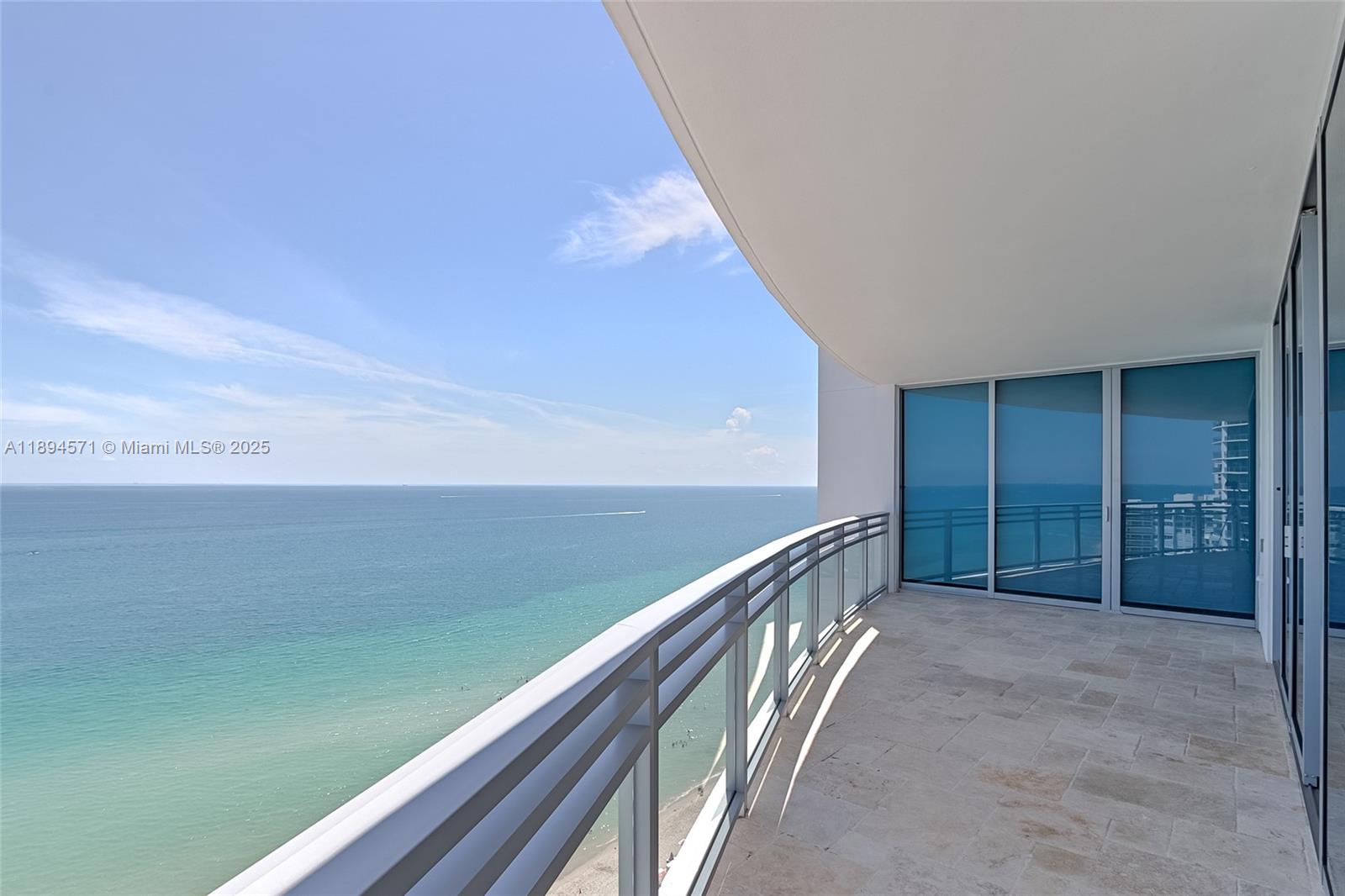 A high-rise balcony with a stone floor, glass railing, and panoramic ocean views — 3535 S OCEAN DR # 2102, Hollywood FL 33019, HOLLYWOOD, FL