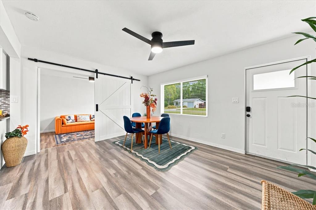 A galley kitchen features white cabinets, stainless steel appliances, and a mosaic tile backsplash — 6350 60TH AVENUE N, ST PETERSBURG, FL