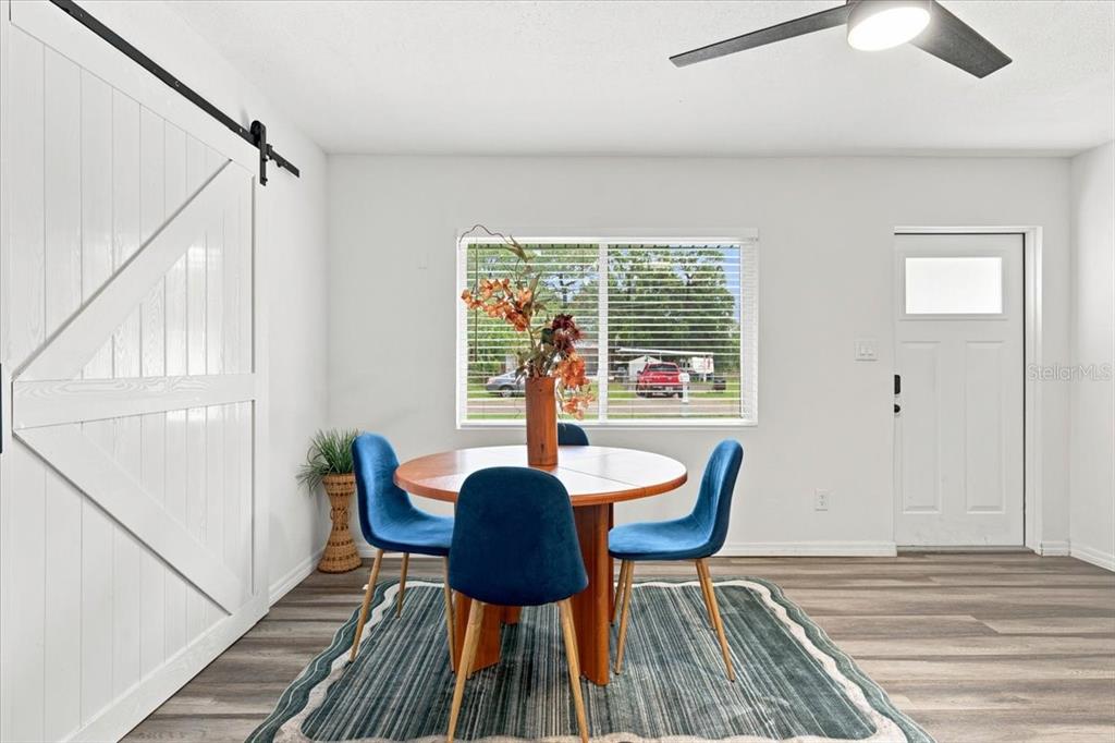 A patio features a fire pit table, outdoor seating, and a patterned rug near a house — 6350 60TH AVENUE N, ST PETERSBURG, FL
