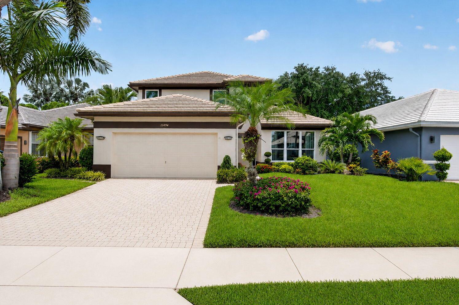 A two-story suburban house with a beige stucco exterior, a tiled roof, and a paved driveway — 13494 Carrick Green Court, Delray Beach FL 33446, DELRAY BEACH, FL