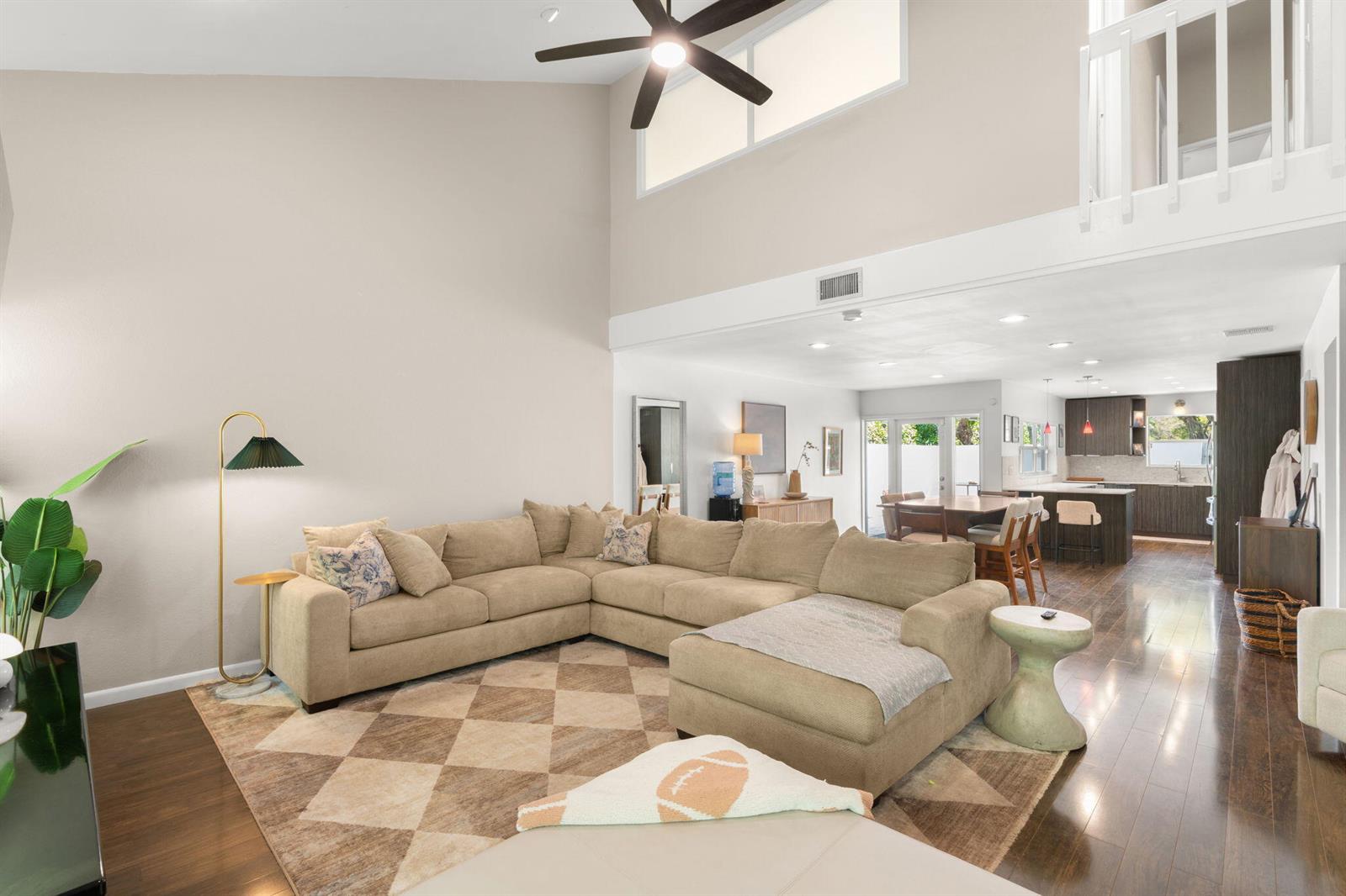 A living room with a sectional sofa, vaulted ceiling, and an open view to the kitchen — 2956 Florida Boulevard, Delray Beach FL 33483, DELRAY BEACH, FL