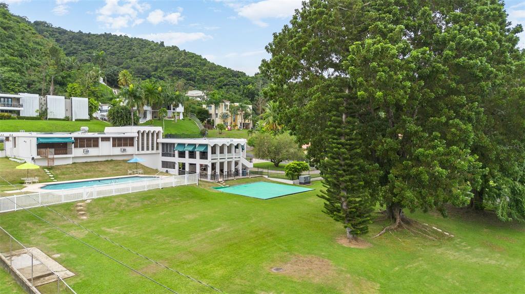 An exterior view of a house with a swimming pool, lawn, and large trees — B CONSTITUCION ST. EL RETIRO DEVELOPMENT LOT A-4, CAGUAS, PR