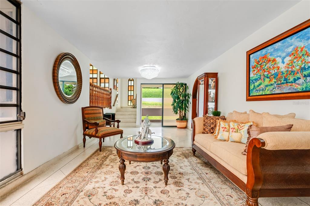 A living room features a beige sofa, a round coffee table, and a patterned area rug — B CONSTITUCION ST. EL RETIRO DEVELOPMENT LOT A-4, CAGUAS, PR