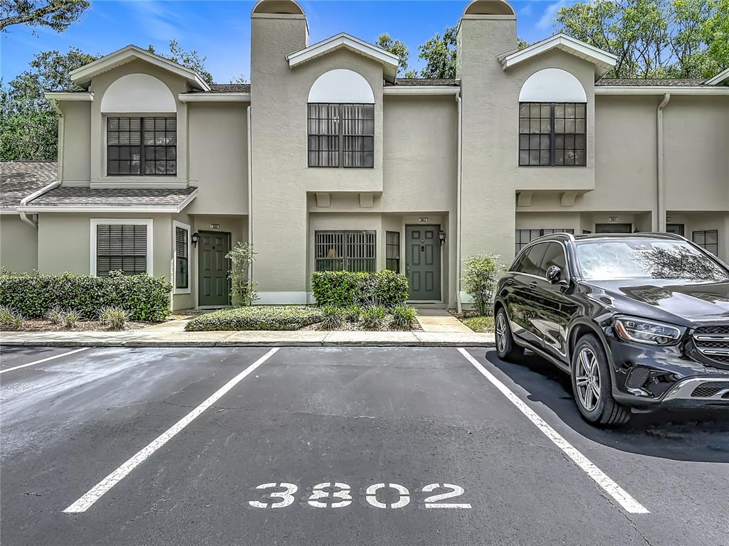 A black SUV is parked in front of a two-story townhouse with beige stucco siding — 5100 BURCHETTE ROAD UNIT 3802, TAMPA, FL