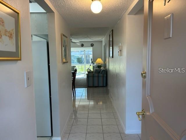 A view from an entryway looking down a tiled hallway toward a living room — 2060 MARILYN STREET UNIT 124, CLEARWATER, FL