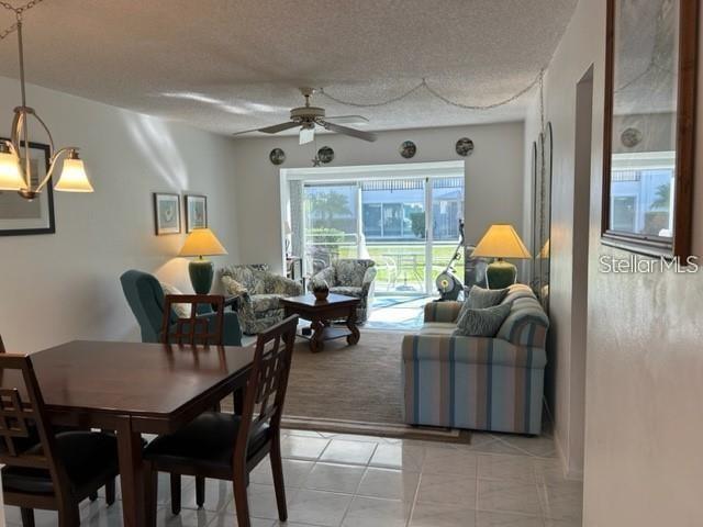 A dining area opens into a living room with a ceiling fan and sliding glass doors — 2060 MARILYN STREET UNIT 124, CLEARWATER, FL