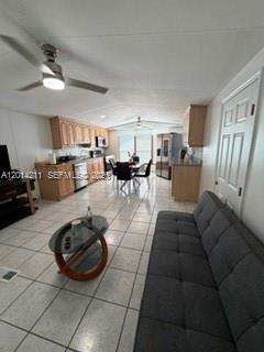 An open-concept living room and kitchen area features light wood cabinetry and tile flooring — 114 Lone Pine Drive, Hallandale Beach FL 33009, HALLANDALE BEACH, FL