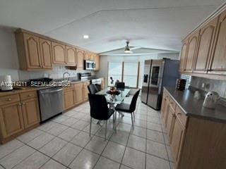 A kitchen features light wood cabinets, stainless steel appliances, and a glass-top dining table — 114 Lone Pine Drive, Hallandale Beach FL 33009, HALLANDALE BEACH, FL
