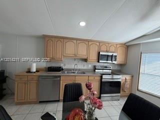 A kitchen with light wood cabinets, stainless steel appliances, and a tiled floor — 114 Lone Pine Drive, Hallandale Beach FL 33009, HALLANDALE BEACH, FL