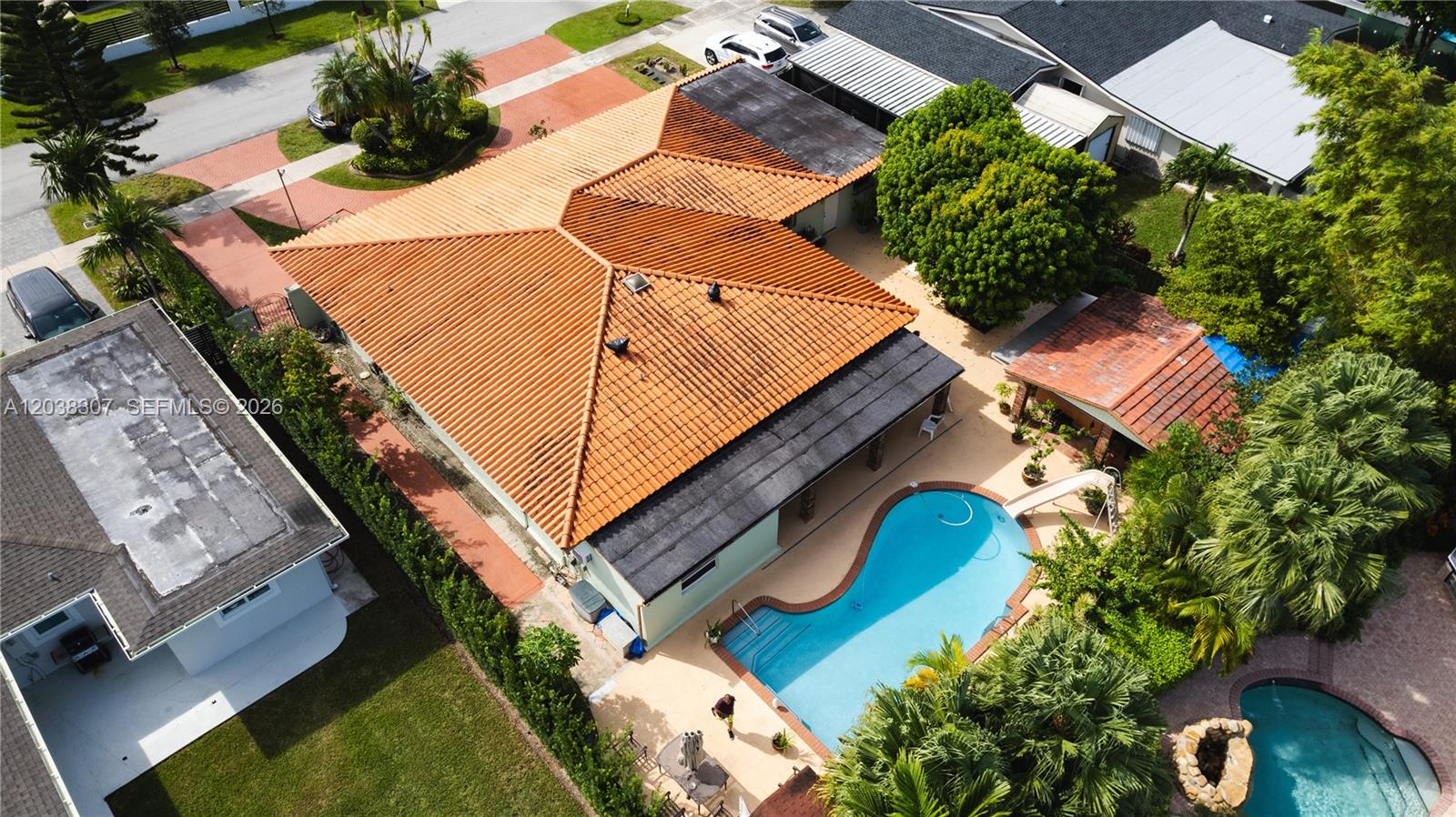 An aerial view shows a house with a terracotta tile roof, pool, and patio area — 9601 SW 66th St, Miami FL 33173, MIAMI, FL