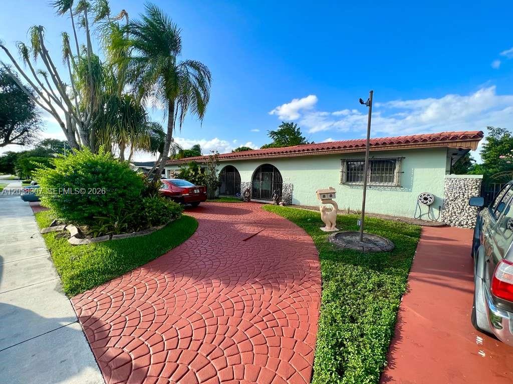 A single-story house with a red patterned driveway, arched entryways, and a tile roof — 9601 SW 66th St, Miami FL 33173, MIAMI, FL