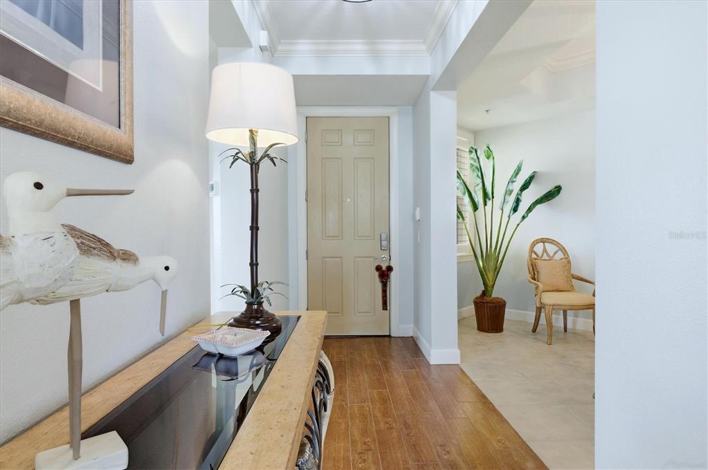 A foyer features a wood-topped console table, a palm-style lamp, and a light-colored door — 8571 AMBERJACK CIRCLE UNIT 304, ENGLEWOOD, FL