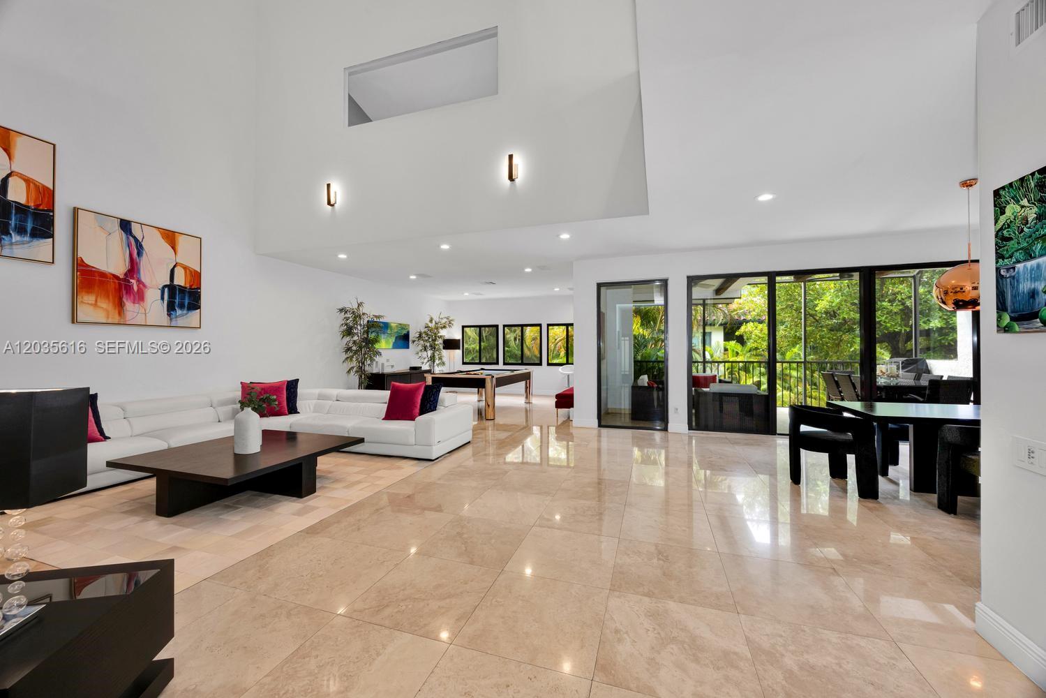 A spacious living room features white walls, tile flooring, a sectional sofa, and a pool table — 2000 S Bayshore Dr # 65, Miami FL 33133, MIAMI, FL