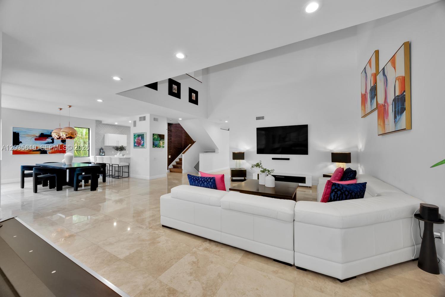 A spacious living and dining area features white walls, tile flooring, and modern furniture — 2000 S Bayshore Dr # 65, Miami FL 33133, MIAMI, FL