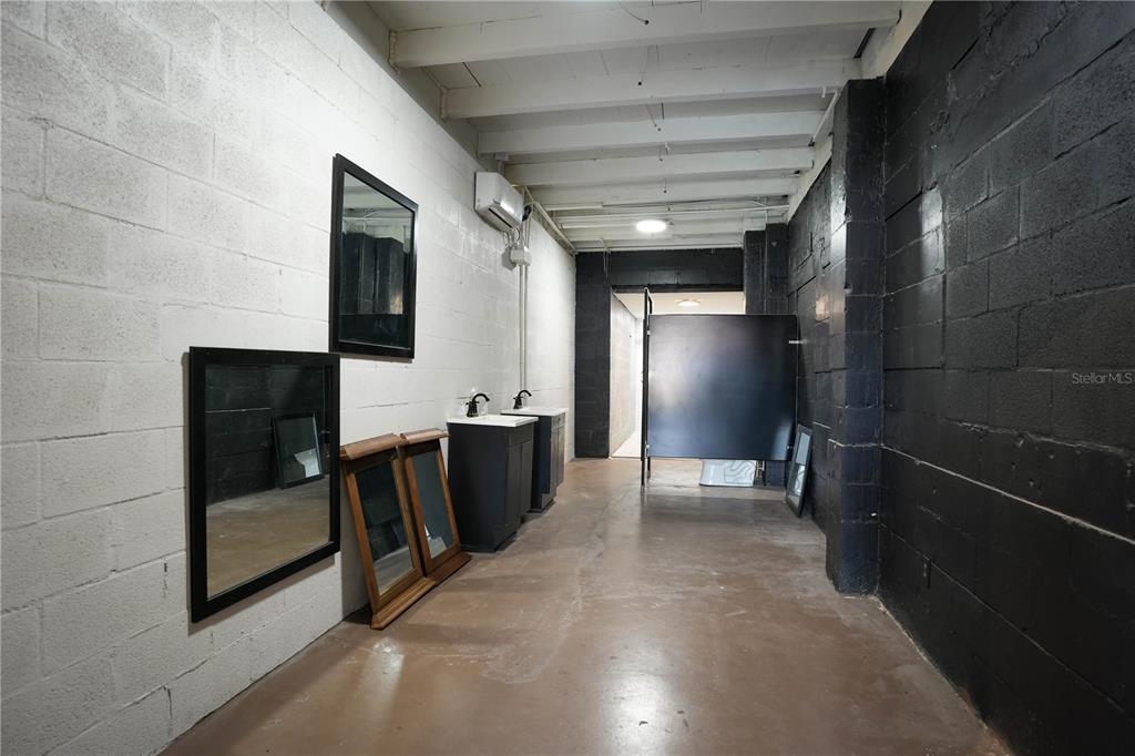 A room with white and black painted cinder block walls, exposed ceiling joists, and two vanities — 4700 22ND AVENUE S UNIT 3, ST PETERSBURG, FL