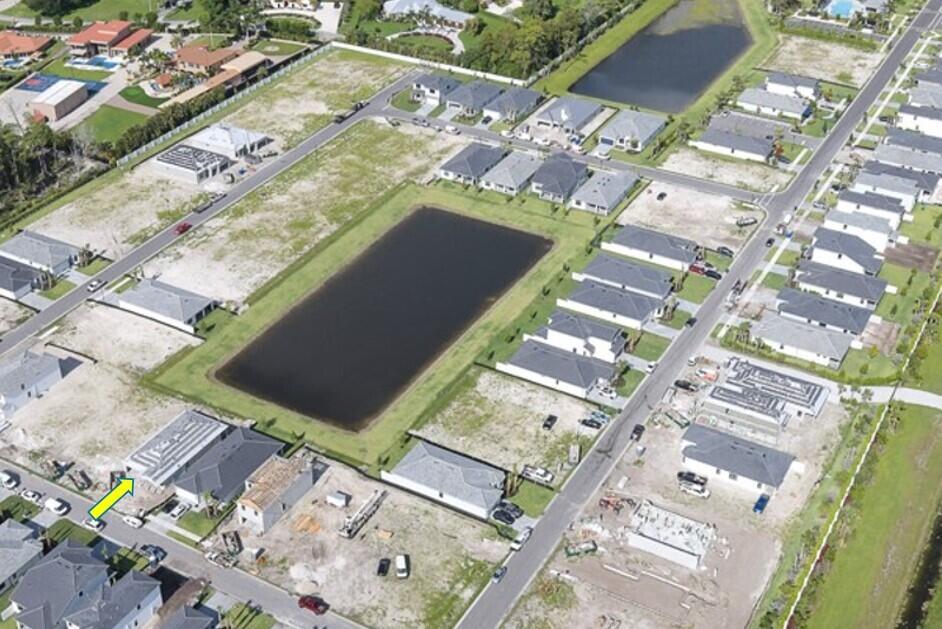 Aerial view of a suburban neighborhood featuring a central retention pond and several houses — 4375 Sipora Court # 77, Lake Worth FL 33467, LAKE WORTH, FL
