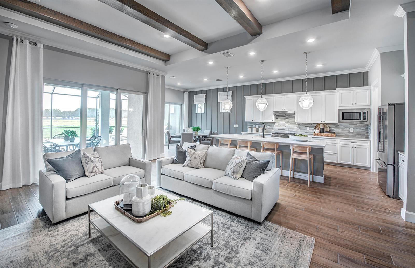 An open-concept living room and kitchen feature wood-look tile floors, exposed ceiling beams, and cabinetry — 4375 Sipora Court # 77, Lake Worth FL 33467, LAKE WORTH, FL