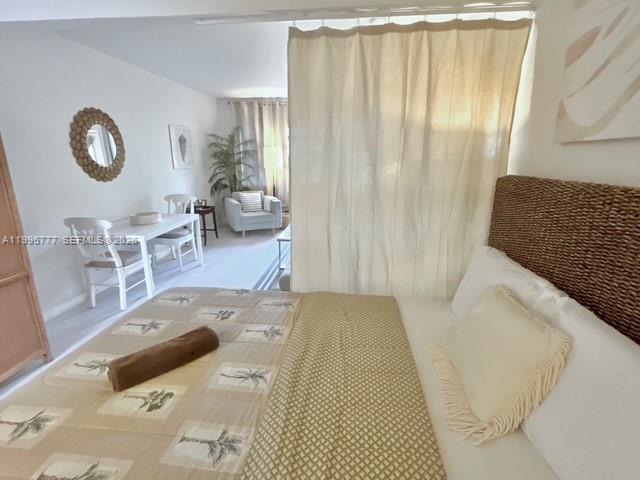 A bedroom features a woven headboard, a patterned bedspread, and a curtained partition — 1050 Pennsylvania Ave # 28, Miami Beach FL 33139, MIAMI BEACH, FL