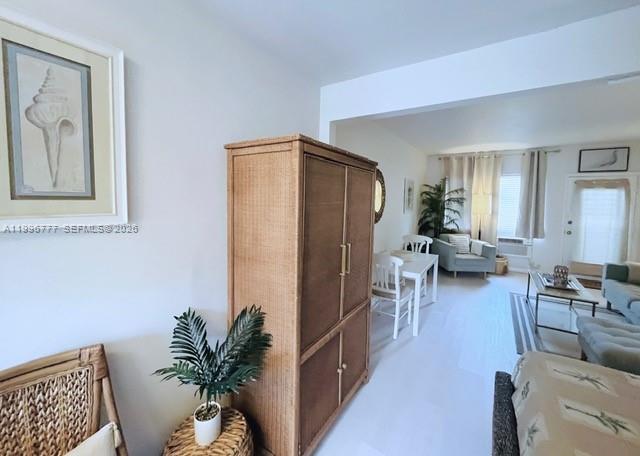 A living and dining area features a wicker armoire, light flooring, and neutral furniture — 1050 Pennsylvania Ave # 28, Miami Beach FL 33139, MIAMI BEACH, FL