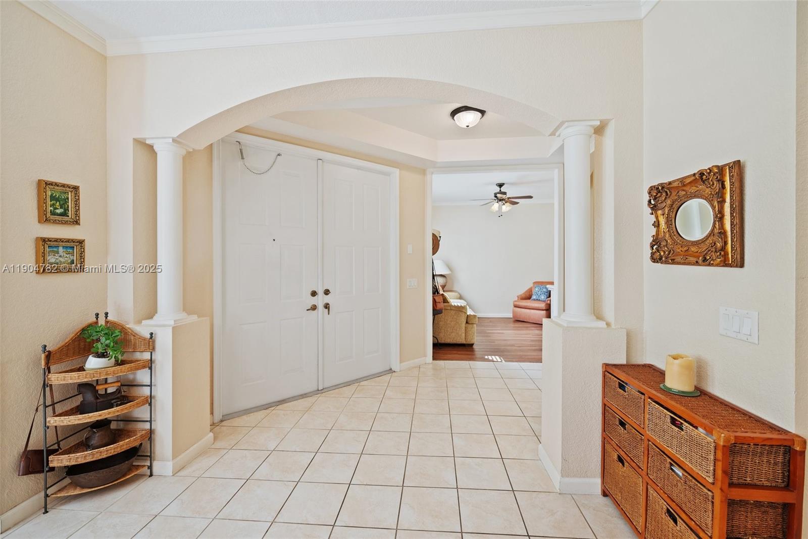An entryway features tiled floors, white double doors, arched architectural details, and two decorative columns — 1634 Passion Vine Cir # 2, Weston FL 33326, WESTON, FL