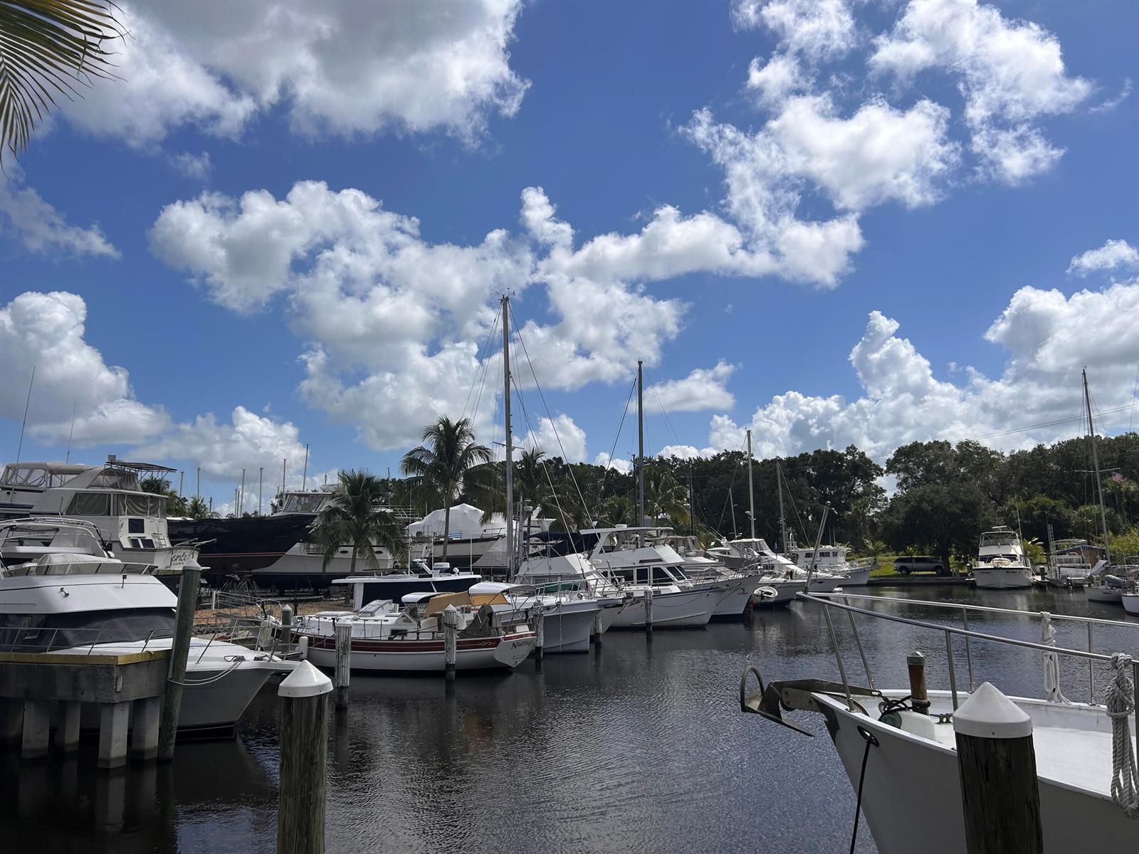 A marina with several docked boats under a bright blue sky with white clouds — 13663 SW Vine Drive, FL 34956, FL