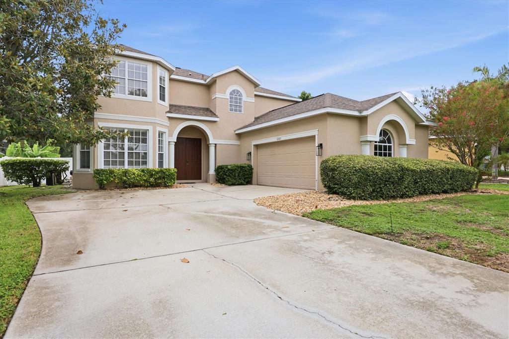 A two-story beige house with a two-car garage and a concrete driveway — 4907 50TH AVENUE W, BRADENTON, FL