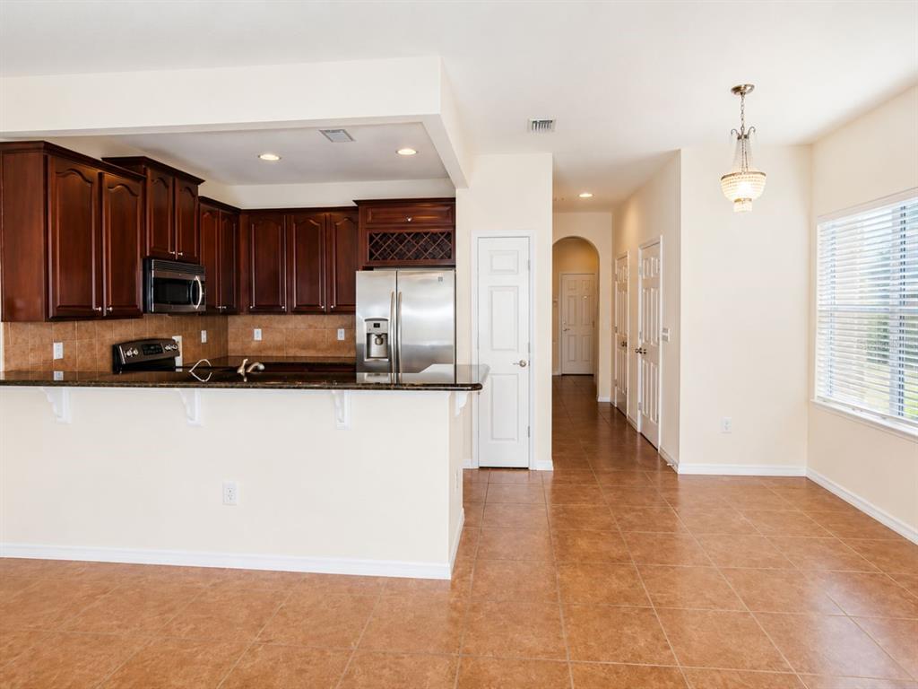 A kitchen with dark wood cabinets, stainless steel appliances, and tile flooring — 1515 BOWMORE DRIVE, CLEARWATER, FL