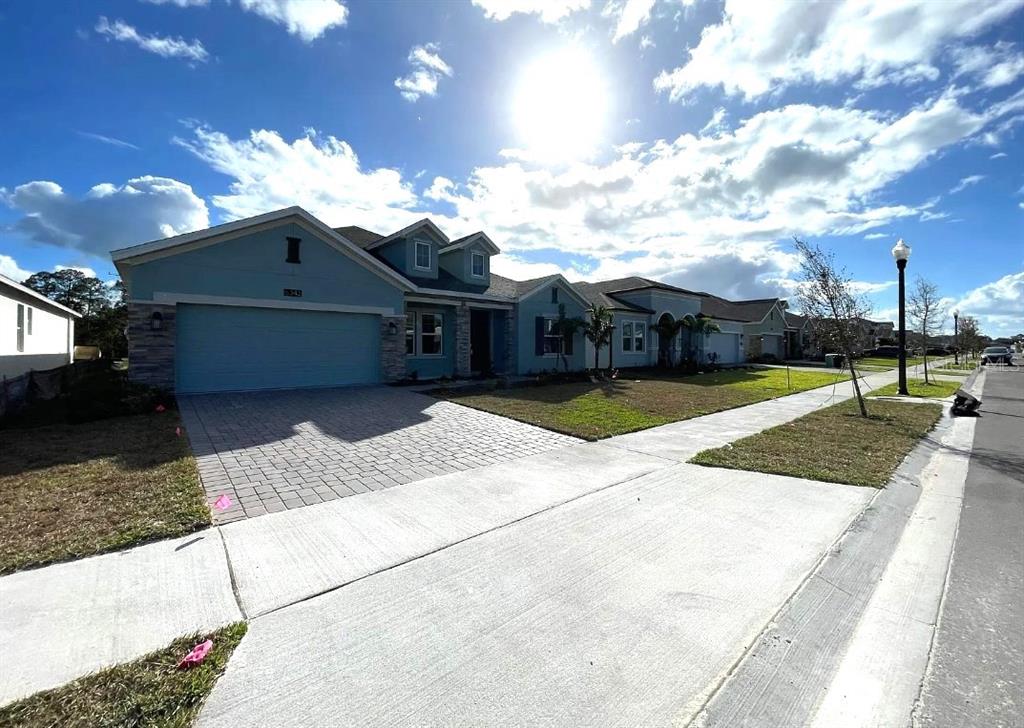 A single-story house with a blue exterior, stone accents, and a paved driveway — 6342 LAKEPINE STREET, ST CLOUD, FL