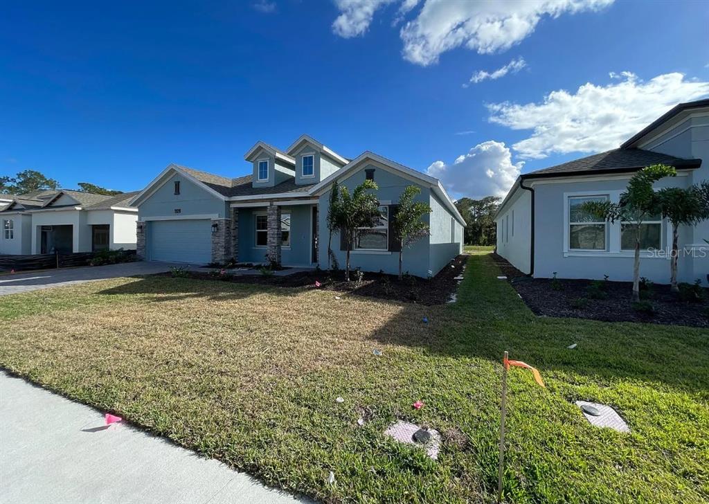 A light blue single-story house with a stone-accented garage and a front lawn — 6342 LAKEPINE STREET, ST CLOUD, FL