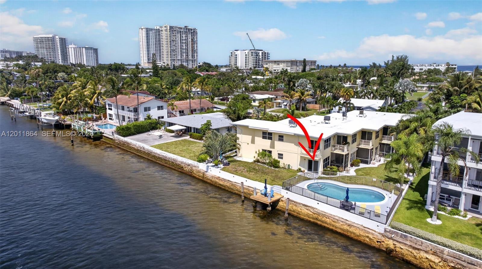 An aerial view shows a waterfront apartment building with a pool and a red arrow — 615 S Riverside Dr # 5, Pompano Beach FL 33062, POMPANO BEACH, FL