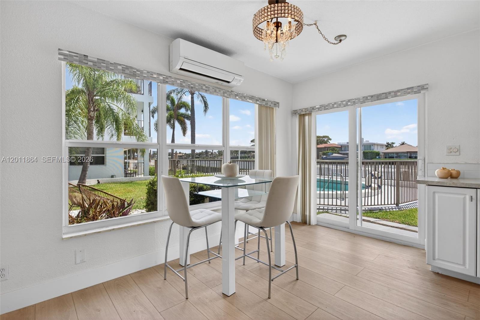 A dining area features a glass table, four chairs, and sliding doors overlooking a pool — 615 S Riverside Dr # 5, Pompano Beach FL 33062, POMPANO BEACH, FL