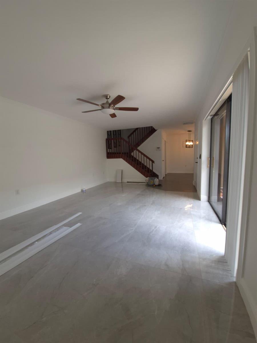 A two-story building exterior with a paved courtyard, balconies, and sliding glass doors — 5012 50th Way, West Palm Beach FL 33409, WEST PALM BEACH, FL