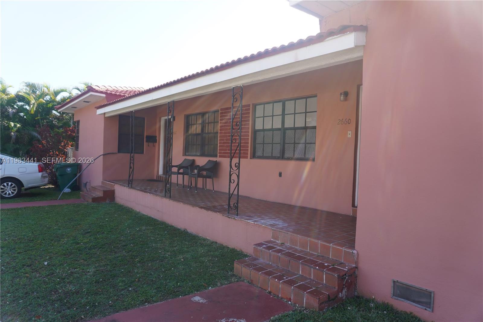 A pink house features a tiled front porch with decorative iron columns and steps — 2660 SW 36th Ave, Miami FL 33133, MIAMI, FL