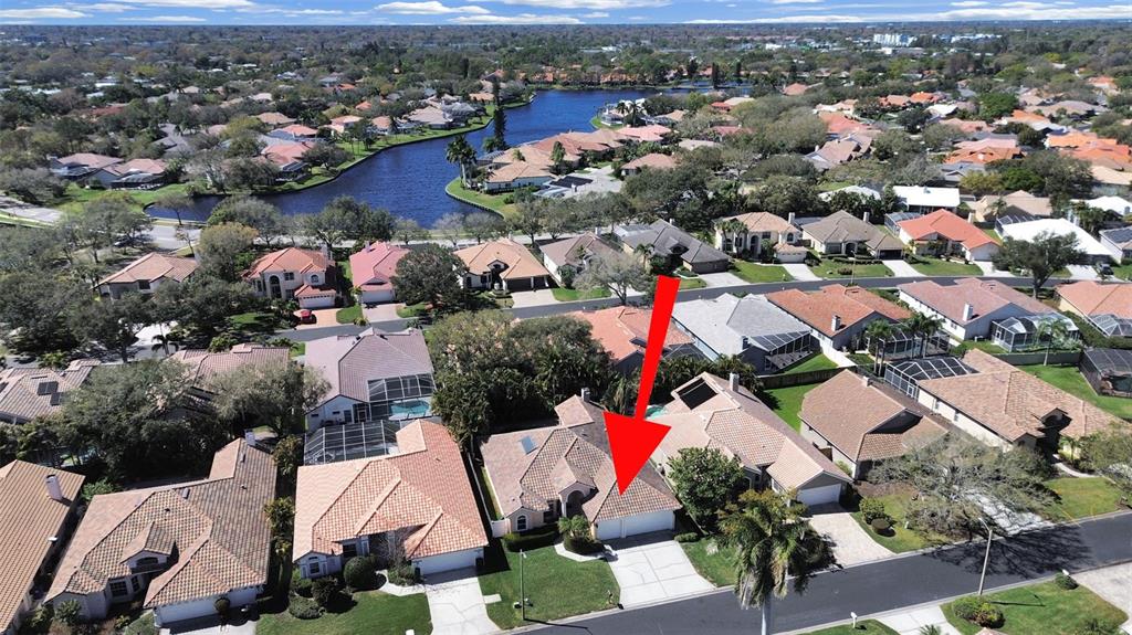 An aerial view shows a suburban house with a tiled roof and a concrete driveway — 4833 WINDMILL PALM TERRACE NE, ST PETERSBURG, FL