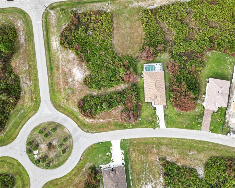 This aerial view shows a residential street with a cul-de-sac and several houses — 442 ALBATROSS ROAD, ROTONDA WEST, FL