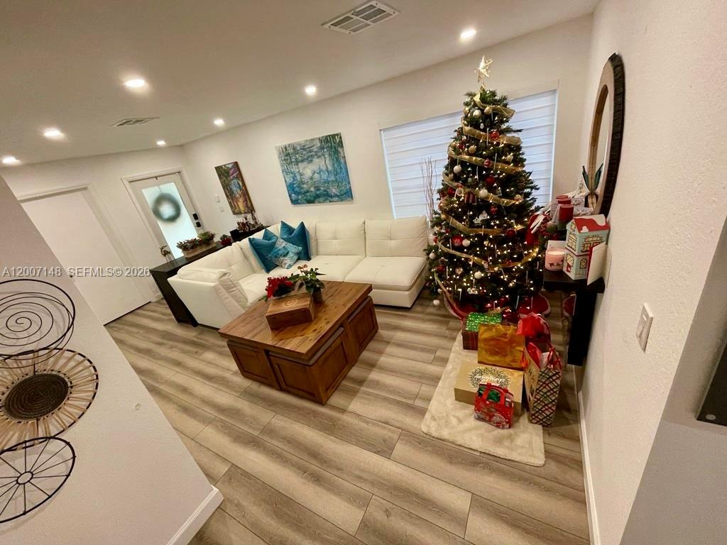 A living room features a white sectional sofa, a wooden coffee table, and a Christmas tree — 1149 NW 126th Pl # 0, Miami FL 33182, MIAMI, FL