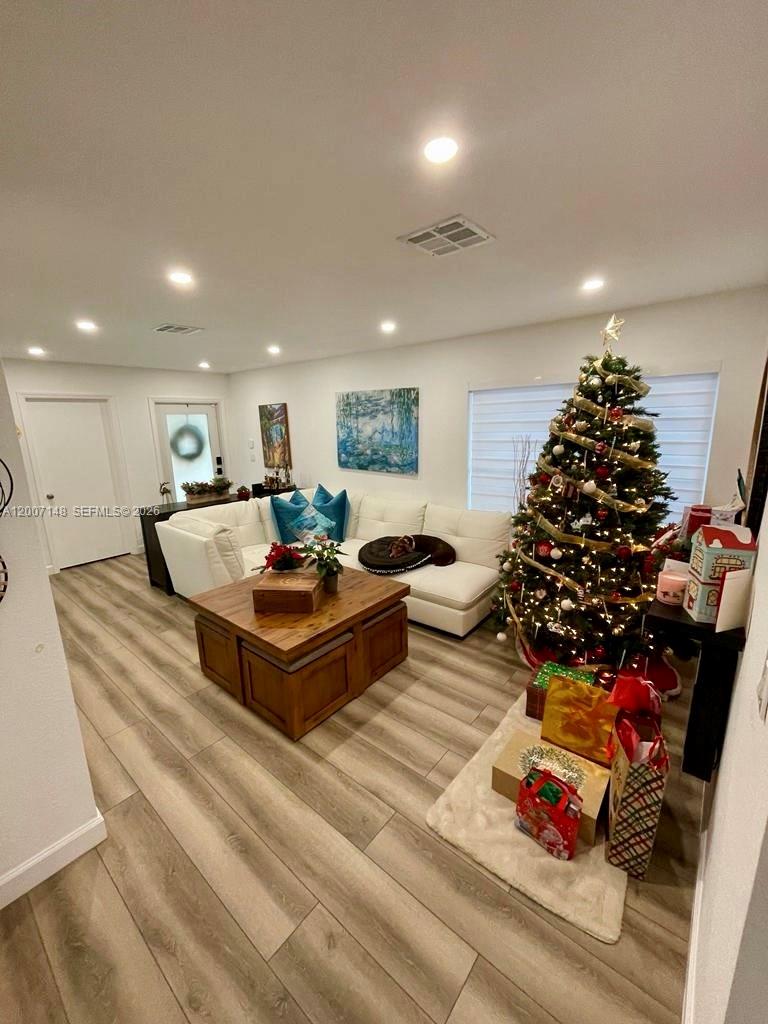 A living room features a white sectional sofa, a wooden coffee table, and a Christmas tree — 1149 NW 126th Pl # 0, Miami FL 33182, MIAMI, FL