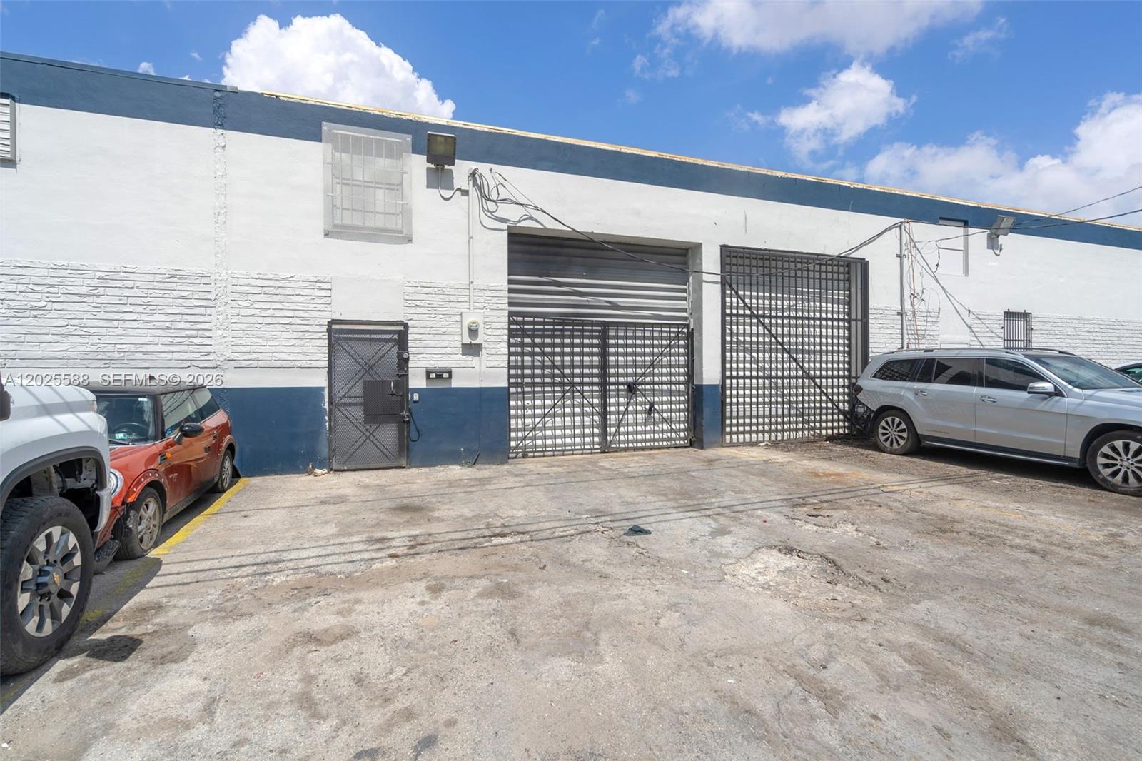 The exterior of a commercial building features two roll-up doors and a pedestrian door — 3500 NW 54th St # 5214, Miami FL 33142, MIAMI, FL