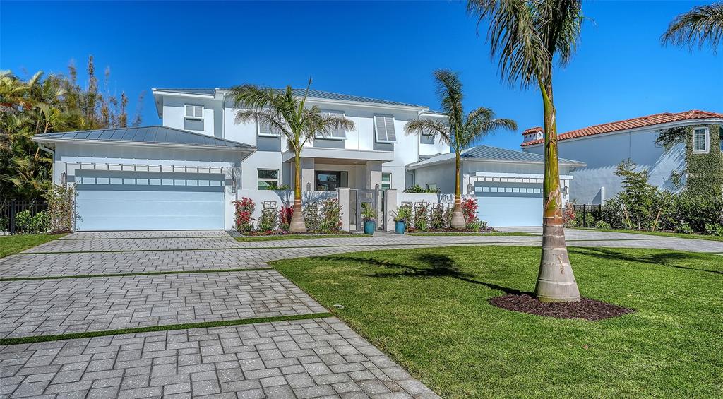 A two-story house with a paved driveway, two garages, and palm trees in the front yard — 1521 S LAKE SHORE DRIVE, SARASOTA, FL