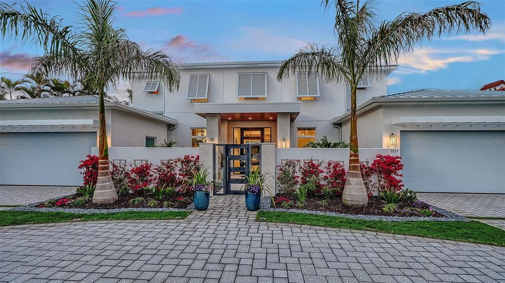 A two-story white house with a paved driveway, palm trees, and two attached garages — 1521 S LAKE SHORE DRIVE, SARASOTA, FL