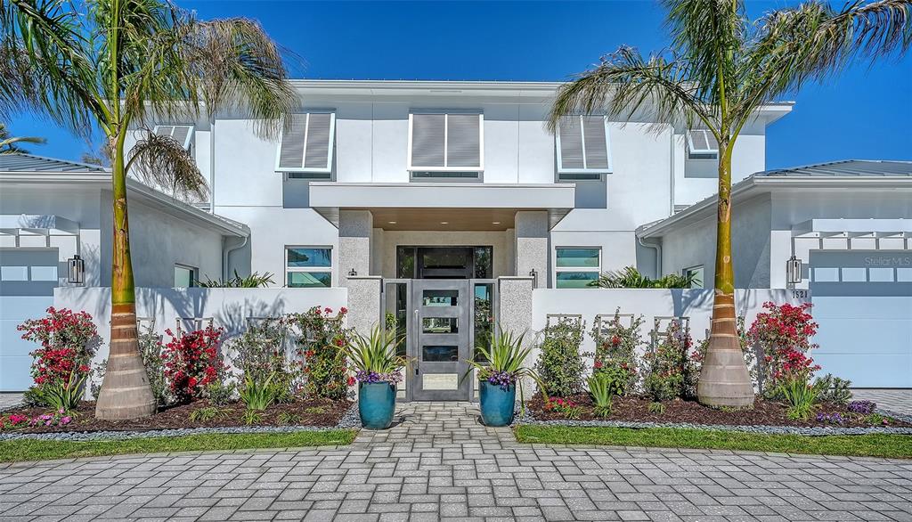 A modern two-story house features a paved driveway, palm trees, and a gated courtyard entrance — 1521 S LAKE SHORE DRIVE, SARASOTA, FL