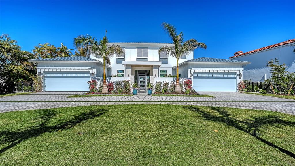 A modern two-story white house features a gated courtyard entrance with palm trees and landscaping — 1521 S LAKE SHORE DRIVE, SARASOTA, FL
