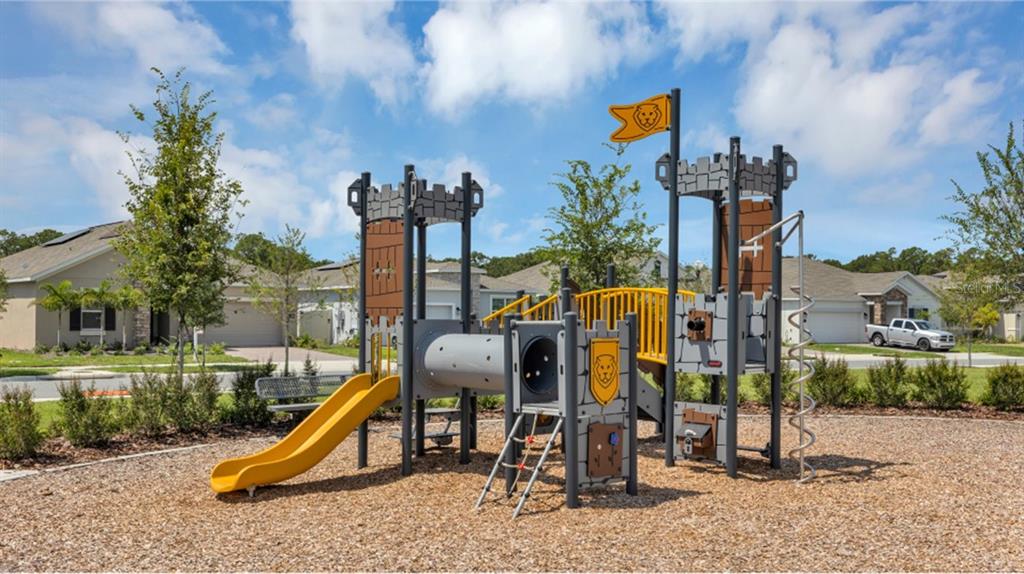 A castle-themed playground structure sits on a wood-chipped surface in a residential neighborhood — 5579 MORANT BAY PATH, KISSIMMEE, FL