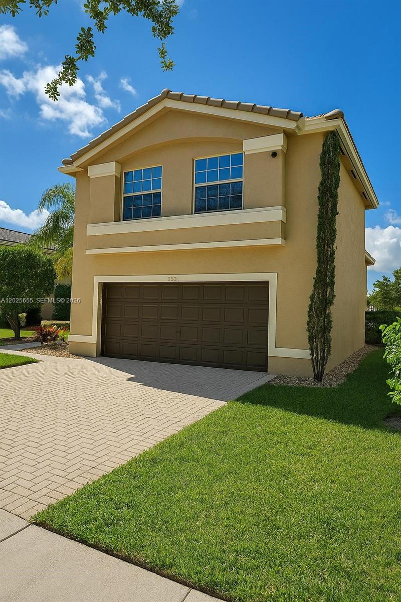 A two-story tan house features a two-car garage and a paved driveway — 2950 SW 163rd Ave # 0, Miramar FL 33027, MIRAMAR, FL