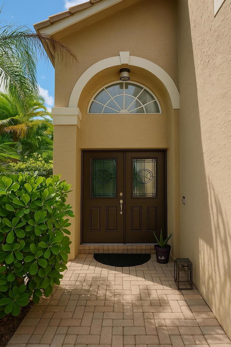 A tan house exterior features a double front door with glass inserts and an arched window — 2950 SW 163rd Ave # 0, Miramar FL 33027, MIRAMAR, FL