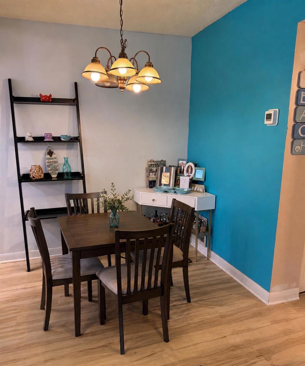 A dining area features a wooden table, four chairs, a ladder shelf, and a console table — 2400 NE 10th Street # 106, Pompano Beach FL 33062, POMPANO BEACH, FL