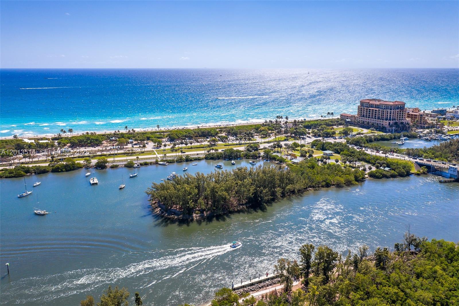 An aerial view shows a coastal waterway with boats, a small island, and a beach — HOLLYWOOD, FL