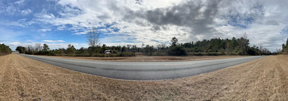A panoramic view of a vacant corner lot bordered by paved roads and wooded areas — 00 SW CR 249, JASPER, FL